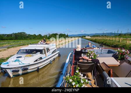 Fahren Sie an Bord der Hotelkahn „L’Esperance“ auf dem Canal du Midi. Touristen genießen die Sonne auf dem Deck des Hotelkahns Stockfoto