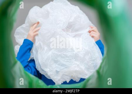 Aufrollbare Kunststoffverpackung mit niedriger Sichtweite in einem Abfalleimer, Recycling- und Abfallsortierkonzept Stockfoto