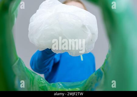 Aufrollbare Kunststoffverpackung mit niedriger Sichtweite in einem Abfalleimer, Recycling- und Abfallsortierkonzept Stockfoto