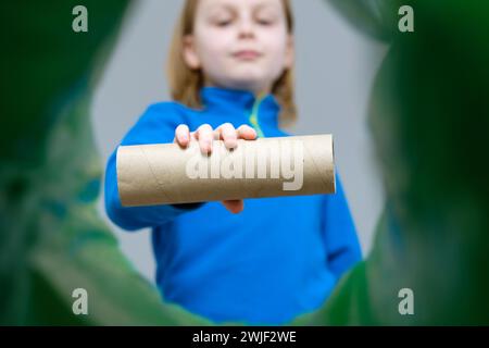 Niedriger Blickwinkel – Aufrollen von Kraftpapier oder Toilettenpapier in einem Abfalleimer, Recycling- und Abfallsortierkonzept Stockfoto