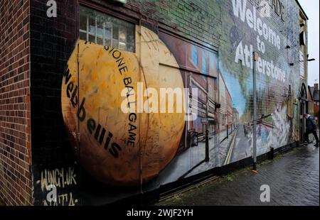 Eine Plakatwand begrüßt Besucher in Atherstone mit einem Wandgemälde, für die die Stadt berühmt ist, einschließlich des Ballspiels. Die Spieler kommen zusammen, um das Atherstone Ball Game zu spielen. Das Spiel 2024 ist das 824. Und es geht auf das Jahr 1199 zurück. Spieler kämpfen auf der Straße um einen übergroßen Ball. Wer den Ball nach zwei Stunden in der Hand hat, gewinnt. Das Spiel ehrt ein Spiel zwischen Leicestershire und Warwickshire im Jahr 1199, bei dem die Teams eine Tasche Gold als Ball verwendeten. (Foto: Martin Pope/SOPA Images/SIPA USA) Stockfoto