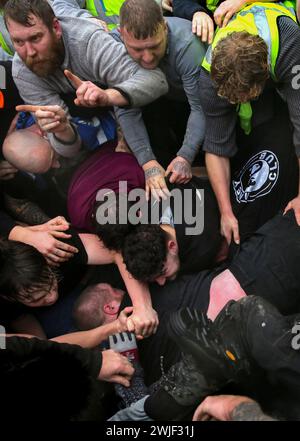 Atherstone, Großbritannien. Februar 2024. Die Spieler erzeugen einen großen Scrum auf der Straße, während sie versuchen, den Ball in die Hände zu bekommen. Die Spieler kommen zusammen, um das Atherstone Ball Game zu spielen. Das Spiel 2024 ist das 824. Und es geht auf das Jahr 1199 zurück. Spieler kämpfen auf der Straße um einen übergroßen Ball. Wer den Ball nach zwei Stunden in der Hand hat, gewinnt. Das Spiel ehrt ein Spiel zwischen Leicestershire und Warwickshire im Jahr 1199, bei dem die Teams eine Tasche Gold als Ball verwendeten. (Foto von Martin Pope/SOPA Images/SIPA USA) Credit: SIPA USA/Alamy Live News Stockfoto