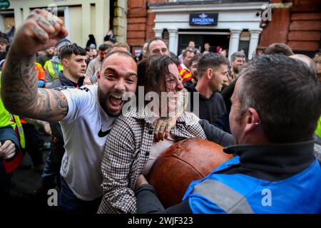 Atherstone, Großbritannien. Februar 2024. Die Spieler feiern, dass sie nach einer frühen Phase des Spiels mit dem Ball anfangen. Die Spieler kommen zusammen, um das Atherstone Ball Game zu spielen. Das Spiel 2024 ist das 824. Und es geht auf das Jahr 1199 zurück. Spieler kämpfen auf der Straße um einen übergroßen Ball. Wer den Ball nach zwei Stunden in der Hand hat, gewinnt. Das Spiel ehrt ein Spiel zwischen Leicestershire und Warwickshire im Jahr 1199, bei dem die Teams eine Tasche Gold als Ball verwendeten. (Foto von Martin Pope/SOPA Images/SIPA USA) Credit: SIPA USA/Alamy Live News Stockfoto