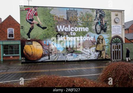 Atherstone, Großbritannien. Februar 2024. Eine Plakatwand begrüßt Besucher in Atherstone mit einem Wandgemälde, für die die Stadt berühmt ist, einschließlich des Ballspiels. Die Spieler kommen zusammen, um das Atherstone Ball Game zu spielen. Das Spiel 2024 ist das 824. Und es geht auf das Jahr 1199 zurück. Spieler kämpfen auf der Straße um einen übergroßen Ball. Wer den Ball nach zwei Stunden in der Hand hat, gewinnt. Das Spiel ehrt ein Spiel zwischen Leicestershire und Warwickshire im Jahr 1199, bei dem die Teams eine Tasche Gold als Ball verwendeten. Quelle: SOPA Images Limited/Alamy Live News Stockfoto