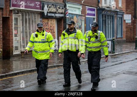 Atherstone, Großbritannien. Februar 2024. Bevor das Spiel beginnt, überprüfen Polizisten die Long Street. Die Spieler kommen zusammen, um das Atherstone Ball Game zu spielen. Das Spiel 2024 ist das 824. Und es geht auf das Jahr 1199 zurück. Spieler kämpfen auf der Straße um einen übergroßen Ball. Wer den Ball nach zwei Stunden in der Hand hat, gewinnt. Das Spiel ehrt ein Spiel zwischen Leicestershire und Warwickshire im Jahr 1199, bei dem die Teams eine Tasche Gold als Ball verwendeten. Quelle: SOPA Images Limited/Alamy Live News Stockfoto