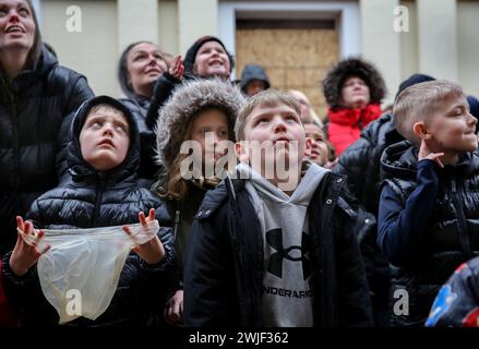 Atherstone, Großbritannien. Februar 2024. Kinder warten mit Taschen auf Süßigkeiten, die aus dem Fenster geworfen werden, bevor das Spiel beginnt. Die Spieler kommen zusammen, um das Atherstone Ball Game zu spielen. Das Spiel 2024 ist das 824. Und es geht auf das Jahr 1199 zurück. Spieler kämpfen auf der Straße um einen übergroßen Ball. Wer den Ball nach zwei Stunden in der Hand hat, gewinnt. Das Spiel ehrt ein Spiel zwischen Leicestershire und Warwickshire im Jahr 1199, bei dem die Teams eine Tasche Gold als Ball verwendeten. (Foto von Martin Pope/SOPA Images/SIPA USA) Credit: SIPA USA/Alamy Live News Stockfoto