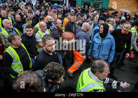 Atherstone, Großbritannien. Februar 2024. Ein Spieler taucht mit dem Ball aus einem Scrum auf. Die Spieler kommen zusammen, um das Atherstone Ball Game zu spielen. Das Spiel 2024 ist das 824. Und es geht auf das Jahr 1199 zurück. Spieler kämpfen auf der Straße um einen übergroßen Ball. Wer den Ball nach zwei Stunden in der Hand hat, gewinnt. Das Spiel ehrt ein Spiel zwischen Leicestershire und Warwickshire im Jahr 1199, bei dem die Teams eine Tasche Gold als Ball verwendeten. Quelle: SOPA Images Limited/Alamy Live News Stockfoto