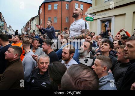 Atherstone, Großbritannien. Februar 2024. Die Spieler sitzen sich gegenseitig Schultern, während sie warten, bis das Spiel beginnt. Die Spieler kommen zusammen, um das Atherstone Ball Game zu spielen. Das Spiel 2024 ist das 824. Und es geht auf das Jahr 1199 zurück. Spieler kämpfen auf der Straße um einen übergroßen Ball. Wer den Ball nach zwei Stunden in der Hand hat, gewinnt. Das Spiel ehrt ein Spiel zwischen Leicestershire und Warwickshire im Jahr 1199, bei dem die Teams eine Tasche Gold als Ball verwendeten. (Foto von Martin Pope/SOPA Images/SIPA USA) Credit: SIPA USA/Alamy Live News Stockfoto