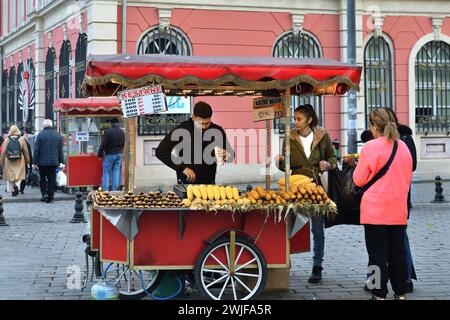 Istanbul, Türkei – 12. Dezember 2023: Einheimische Frauen kaufen gerösteten Mais auf einer Straße. Stockfoto