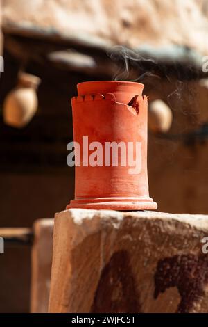 Weihrauchverbrennung im keramischen Weihrauchbrenner im arabischen Souk in Oman. Nahaufnahme mit Fokus auf Rauch. Stockfoto