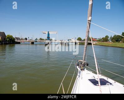 Das Segelboot nähert sich der Brücke und wartet auf die Eröffnung - 1/4, Warnsebrug über den Johan Frisokanaal Kanal in Friesland, Niederlande Stockfoto