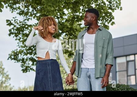 Ein junges afroamerikanisches Paar hält Hände und kommuniziert mit Handgesten im Freien Stockfoto