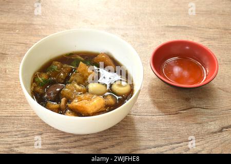 Geschmorter Fischschlamm mit Bambussprossen, garniert gekochtes Ei in roter Soße Suppe auf einer Schüssel Stockfoto