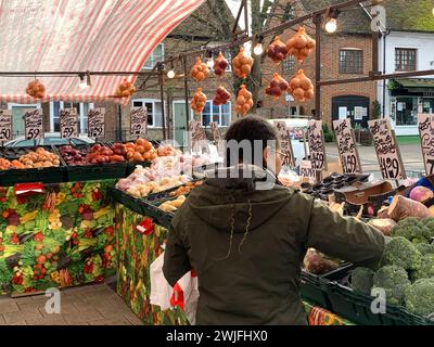 Wendover, Großbritannien. Februar 2024. Eine Dame kauft Gemüse zum Verkauf an einem Obst- und Gemüsestand am Market Day in Wendover, Buckinghamshire. Quelle: Maureen McLean/Alamy Live News Stockfoto
