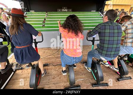 30.09.2023, Paris, FRA - Menschen sitzen auf Ergometern und spielen das Jahrmarkt-Pferdederby. Aussen, Aussenaufnahme, Derby, elektronisch, Ergometer, Europa, europaeisch, Fahrradfahren, Fahrraeder, Frankreich, Franzoesisch, Fun, Galopprennen, Gesellschaft, Gluecksspiel, Jahrmarkt, Jahrmarkt-Pferdederby, Kaukasier, kaukasisch, Menschen, Paris, Personen, Pferderenn-Simulator, Pferderennen, Pferderennspiel, Pferdespiel, QF, Querformat, Radfahren, Rennbahnbesucher, Rummel, Rummelplatz, Spass, Spiel, spielen, strampeln, Westeuropa, Wirtschaft 230930D857LONGCHAMP.JPG *** 30 09 2023, Paris, FRA peop Stockfoto