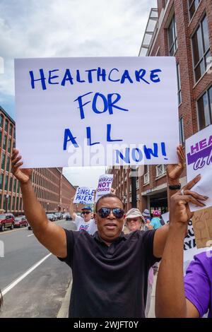 LAWRENCE, MA, USA – 20. JULI 2017: Hispanic man hält ein Protestschild mit der Aufschrift „Healthcare for All“ hoch. Stockfoto