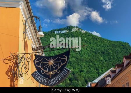 BRASOV, RUMÄNIEN - 11. JULI 2020: Das Logo des Restaurants Karpaten Hirsch in einem alten Gebäude aus der Mitte des 16. Jahrhunderts. Im Backg Stockfoto