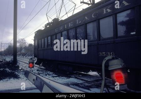 Erie Lackawanna Railway Pendlerzug in der Abenddämmerung. Crossing A Level Crossing in der kleinen Stadt Dover, New Jersey, USA Januar 1982. 1980er Jahre USA. HOMER SYKES Stockfoto