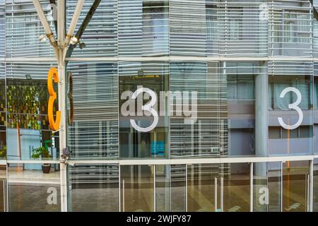 Architektonische Moderne: Die Eleganz des modernen Gebäudes Nr. 3 mit Glasfassaden und Eisengittern Stockfoto