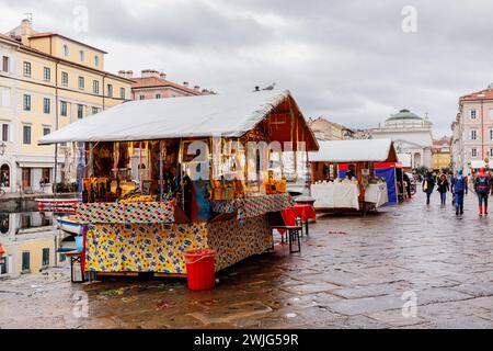 Triest, Italien - 11. Februar 2024: Verkaufsstände von Straßenverkäufern am Ufer des Canal Grande. Stockfoto