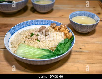 Eine Schüssel Fleischbällchensuppe mit frischem Gemüse auf dem alten Holztisch. Stockfoto