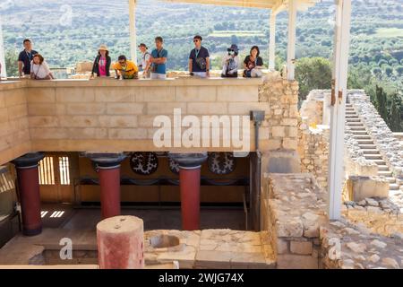 Palast von Minos, archäologische Stätte aus der Bronzezeit von Knossos, Heraklion, Kreta, Griechenland. Besucher, die in einen Teil des Palastes hinunterschauen. Stockfoto