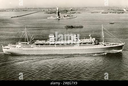 SS Nieuw Amsterdam im Hafen von New York, vorbei an der Freiheitsstatue Stockfoto