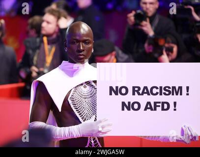 Berlin, Deutschland, 15.02.2024: Berlinale-Palast: 74. Berlinale: Papis Loveday, Model aus dem Senegal, hält auf dem Roten Teppich ein Schild mit der Aufschrift No Rassiism - No AfD *** Berlin, Deutschland, 15 02 2024 Berlinale Palast 74 Berlinale Papis Loveday, Model aus Senegal, hält ein Schild mit der Aufschrift No Rassiism No AfD on the Red Carpet Copyright: xdtsxNachrichtenagenturx dts 30718 Stockfoto