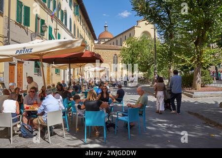 Geschäftige Bars, Piazza Santo Spirito, Otrarno, Florenz, Italien mit Basilika im Hintergrund Stockfoto