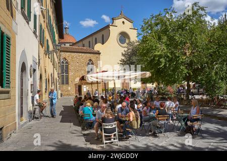 Geschäftige Bars, Piazza Santo Spirito, Otrarno, Florenz, Italien mit Basilika im Hintergrund Stockfoto