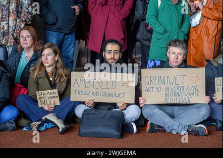 Den Haag, Niederlande. Februar 2024. Die Demonstranten halten Plakate, die ihre Meinung während eines pro-palästinensischen Mittagsprotests zum Ausdruck bringen. Clival Servants, medizinische und Justizarbeiter in den Haag, hielten eine pro-palästinensische Mittagsproteste vor dem Eingang des Außenministeriums ab. Seit dem 7. Oktober startete Israel seine militärischen Angriffe auf den Gazastreifen, bei denen mehr als 28,400 Palästinenser, hauptsächlich Frauen und Kinder, getötet wurden, und mehr als 68.000 Verwundete seit Kriegsbeginn, so das von der Hamas betriebene gesundheitsministerium. Quelle: SOPA Images Limited/Alamy Live News Stockfoto