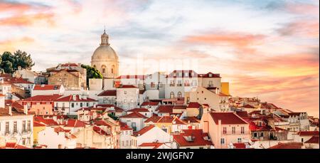 Die Skyline der Altstadt von Portugal, Lissabon im Viertel Alfama. Dramatischer Himmel bei Sonnenuntergang - Stadtreisekonzept. Stockfoto