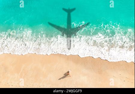 Flugzeugschatten fliegen über einen wunderschönen exotischen tropischen Strand mit einer Frau, die auf einem sonnigen Strand sonnt - Sommerurlaub Reisekonzept Stockfoto