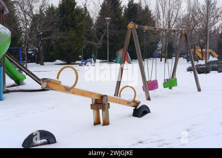 Kinderspielplatz im öffentlichen Park mit Schnee bedeckt Stockfoto