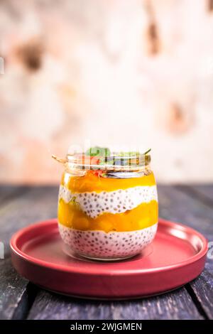 Chiasamenpudding mit Mango, gemischten Beeren, Milch, griechischem Joghurt, verschiedenen Früchten, und Honig. Tropisch inspirierte Köstlichkeiten für einen erfrischenden Sommergenuss. Stockfoto