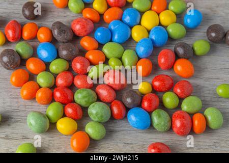 Erdnüsse in Schokolade mehrfarbige Glasur auf einem Holztisch. Draufsicht. Stockfoto