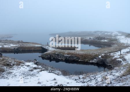 Abend am See. Spätes Tageslicht, Nebel und regnerisches Wetter ließen die Fotos einfarbig mit einem Blauton erscheinen. Details zu den kleinen Vulkaninseln A Stockfoto