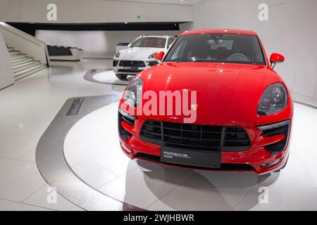 Neuer roter Porsche Macan Turbo, 4x4 Allradantrieb, eleganter Sportwagen im Showroom, nachhaltige Entwicklung, Innovation in der Automobilindustrie Porsche Stockfoto