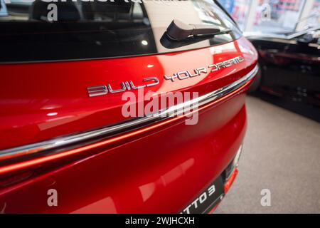 Teil des roten BYD ATTO 3-Fahrzeugs mit Logo, chinesischer BYD-Hersteller für Elektrofahrzeuge, eleganter und dynamischer C-SUV, Innovation in der Automobilindustrie Sho Stockfoto