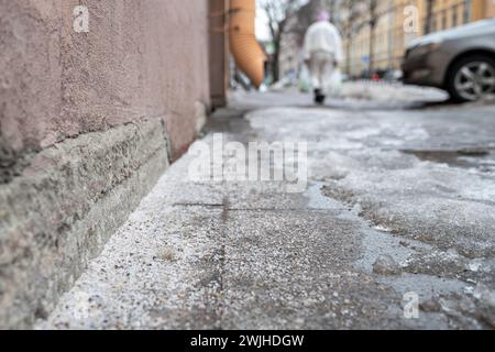 Technische Salzkörner auf vereistem Gehsteig im Winter zum Schmelzen von Eis und Schnee Stockfoto