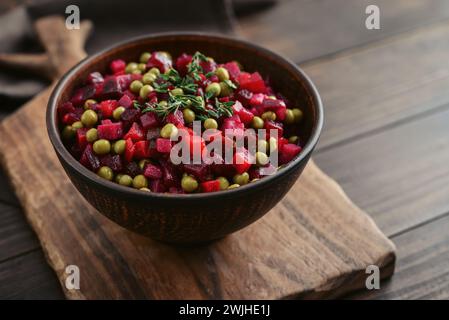 Vinegret – traditioneller russischer Gemüsesalat in Schüssel auf hölzernem Hintergrund, Nahaufnahme Stockfoto