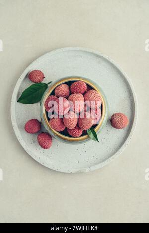 Frisches Bio-Litschi-Obst in der Schüssel auf hellem Hintergrund, Draufsicht Stockfoto