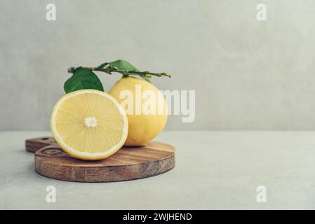 Frische reife Bergamotte-Orangenfrüchte auf Schneidebrett auf hellem Hintergrund Stockfoto