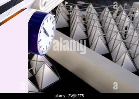 Große moderne Uhr im Flughafen auf einem schönen Hintergrund, geometrische Formen an der Decke, Konzeptverzögerung, Flugstornierung, Ankunftszeit, nicht verpassen Stockfoto