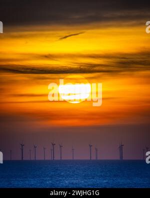 Sonnenuntergang über einem Windpark am Meer Stockfoto