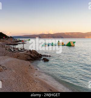 Strohschirme am Strand von Rabac, kroatischer Ferienort an der Kvarner Bucht, direkt südöstlich von Labin in Istrien. Lange ein kleiner Fischerhafen, Rabac Stockfoto