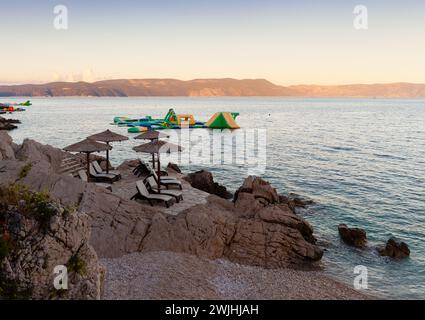 Strohschirme am Strand von Rabac, kroatischer Ferienort an der Kvarner Bucht, direkt südöstlich von Labin in Istrien. Lange ein kleiner Fischerhafen, Rabac Stockfoto