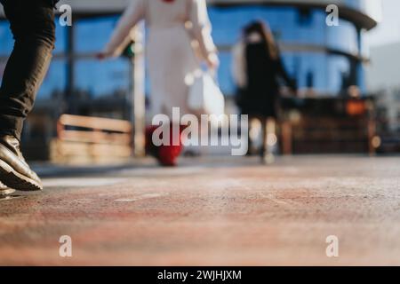 Nahaufnahme von Geschäftsleuten in Bewegung auf einer Stadtstraße, die das Tempo und die Bewegung in einer städtischen Umgebung verdeutlicht. Stockfoto