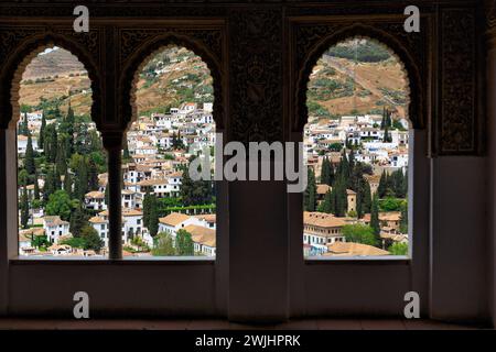 Blick auf die Stadt durch drei Arabesken Bogenfenster, Nasridenpaläste, Alhambra, Granada, Andalusien, Spanien Stockfoto