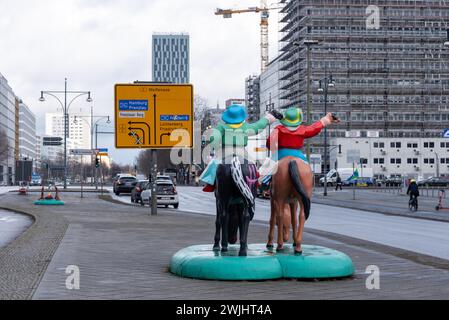 Skulptur von zwei Cowboys auf Pferden, dahinter ein Straßenschild, Berlin Stockfoto